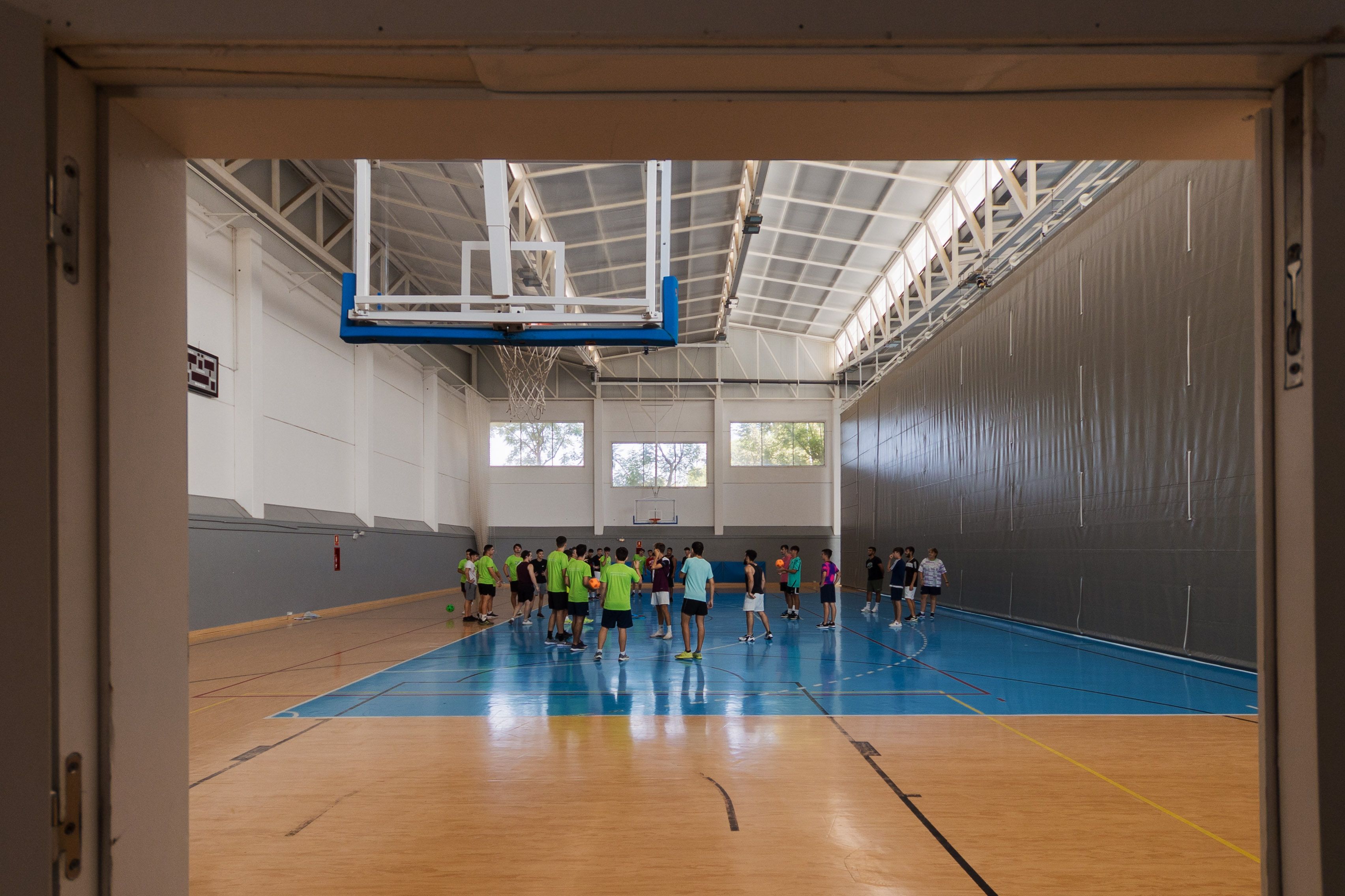 Jóvenes jugando al baloncesto en el pabellón.