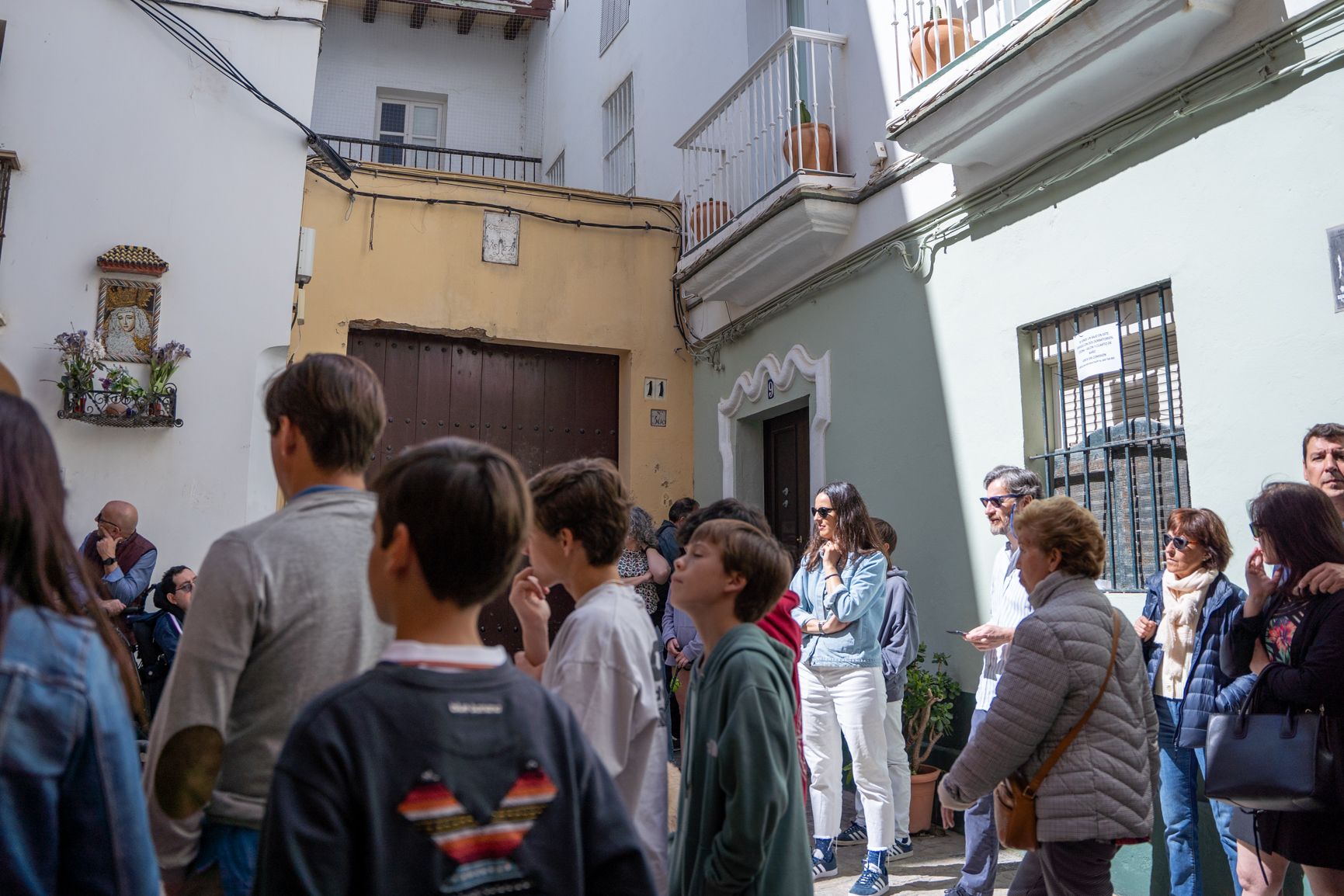 La vivienda que habita María Muñoz, con el portal enmarcado en blanco, tras un corro de turistas con guía este viernes.   REYNA